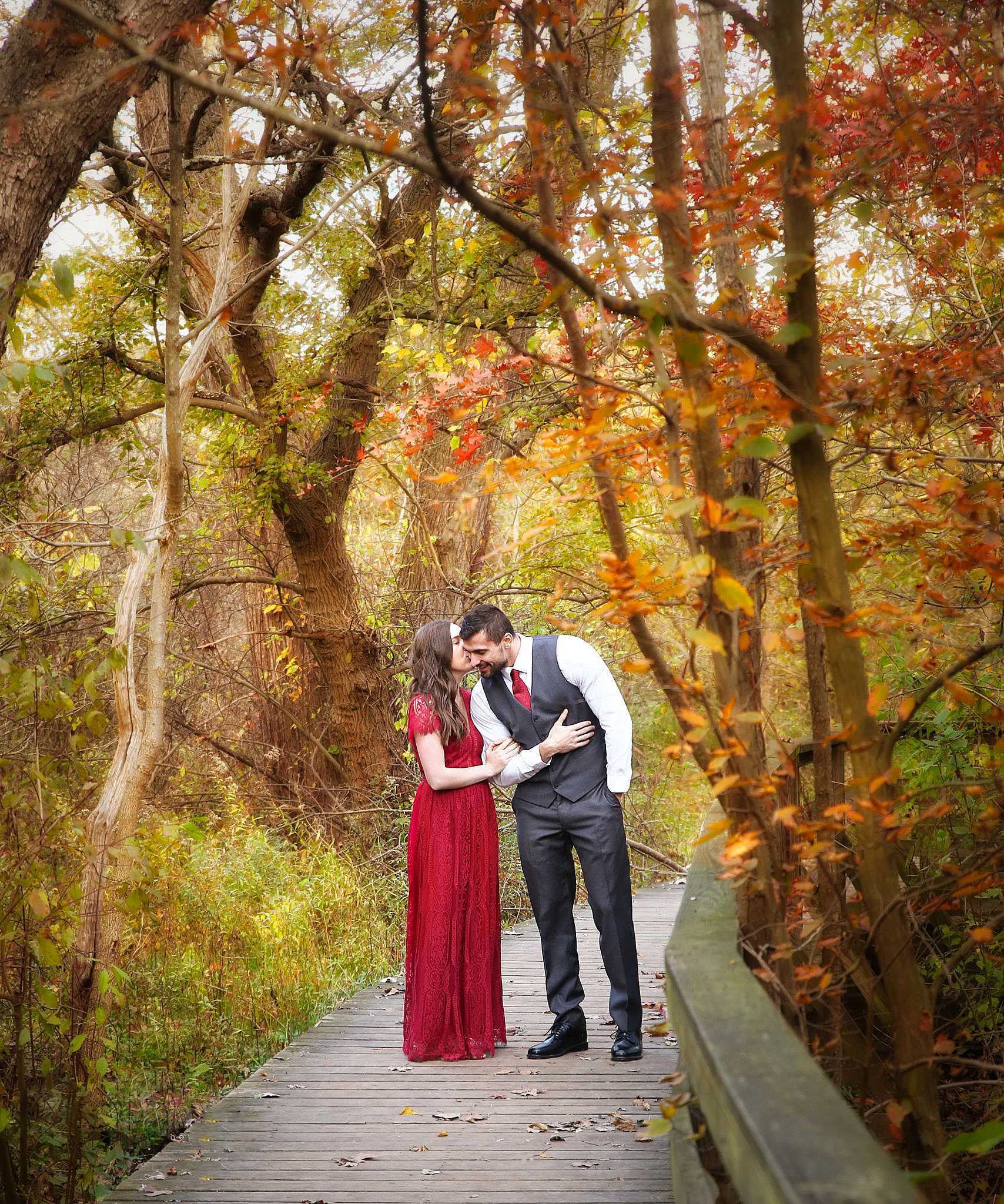 Engagement session — couple kissing in autumn foliage