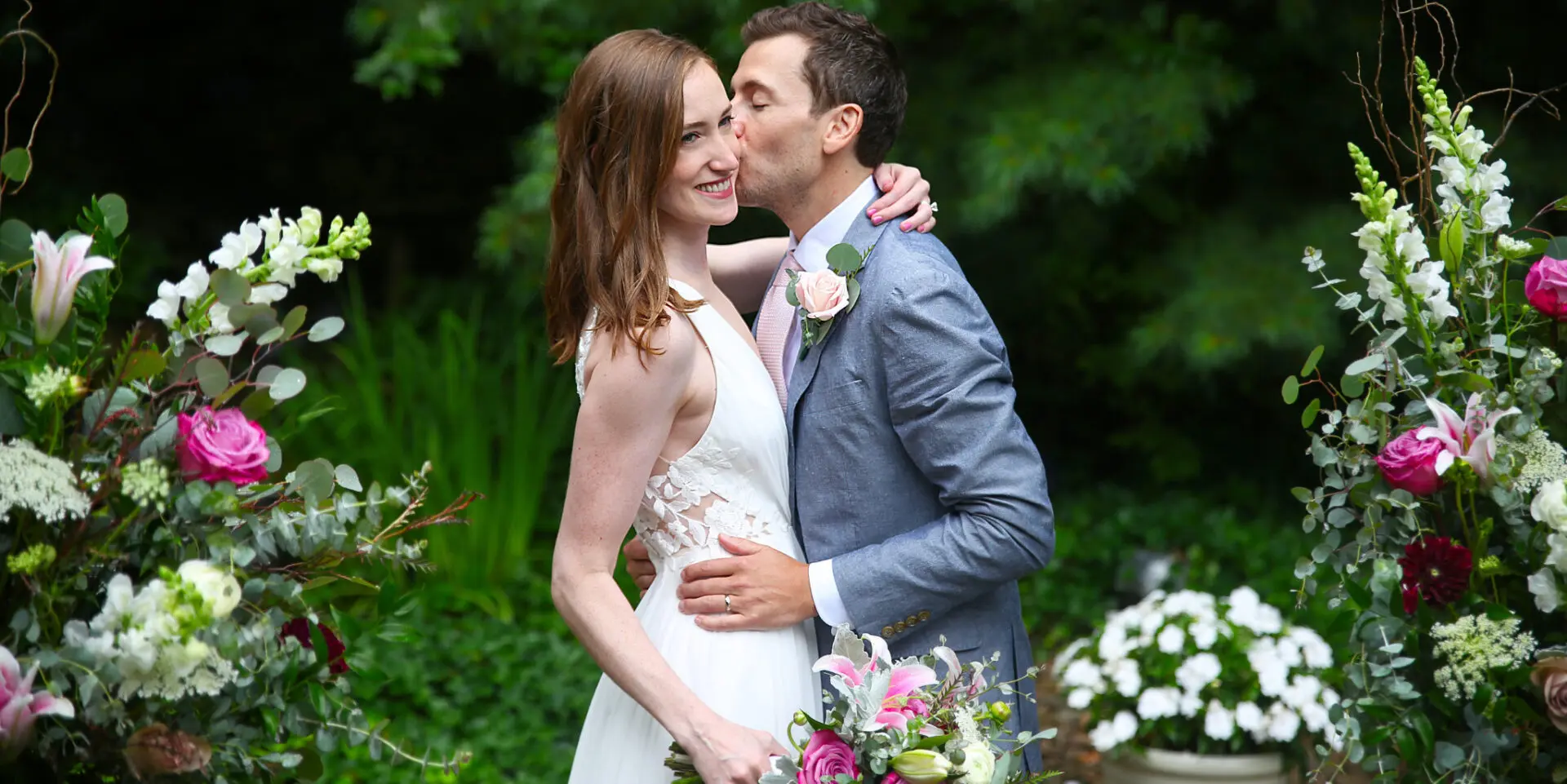 Bride and groom share a romantic kiss in garden