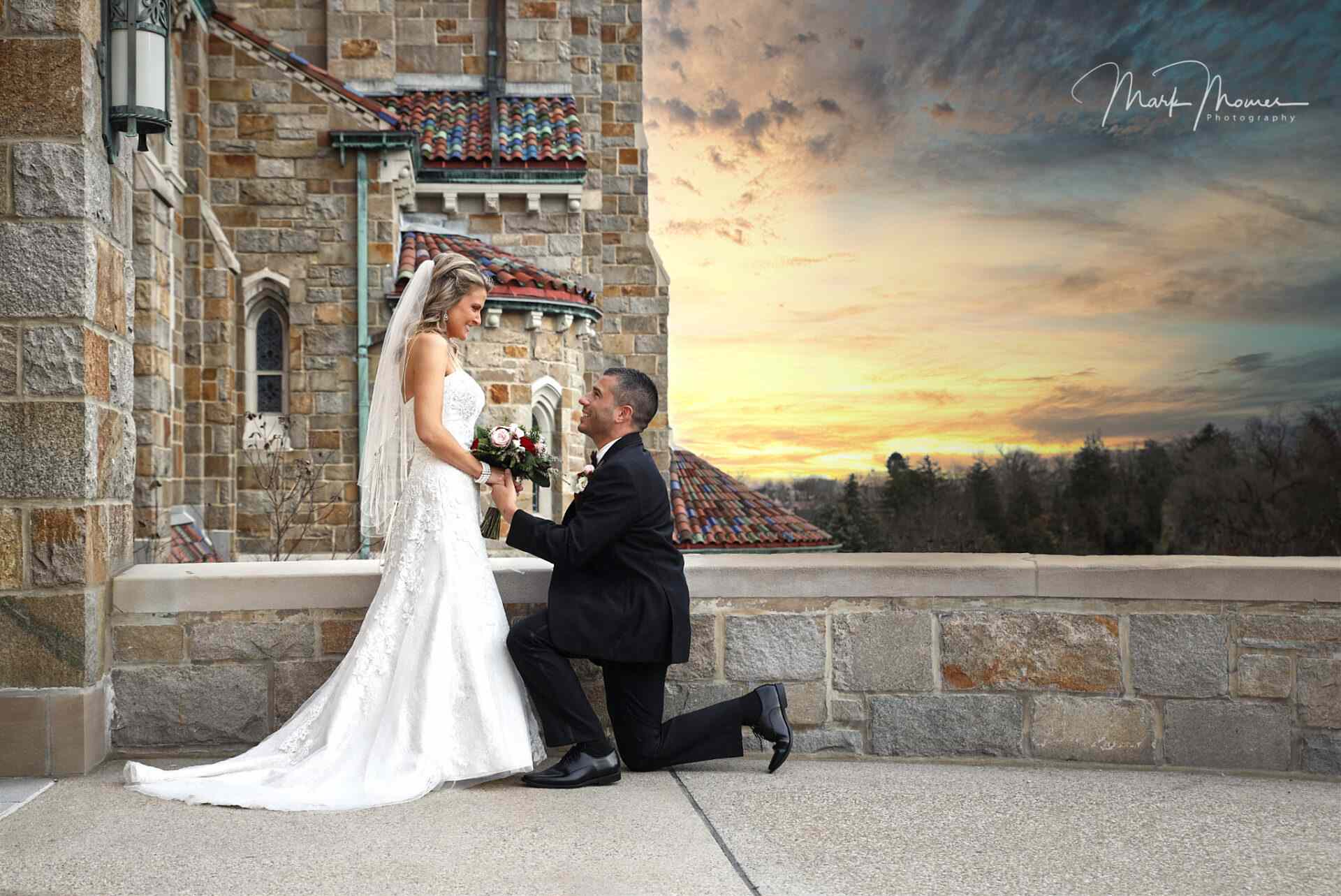 groom kneeling down for his bride in front of the church