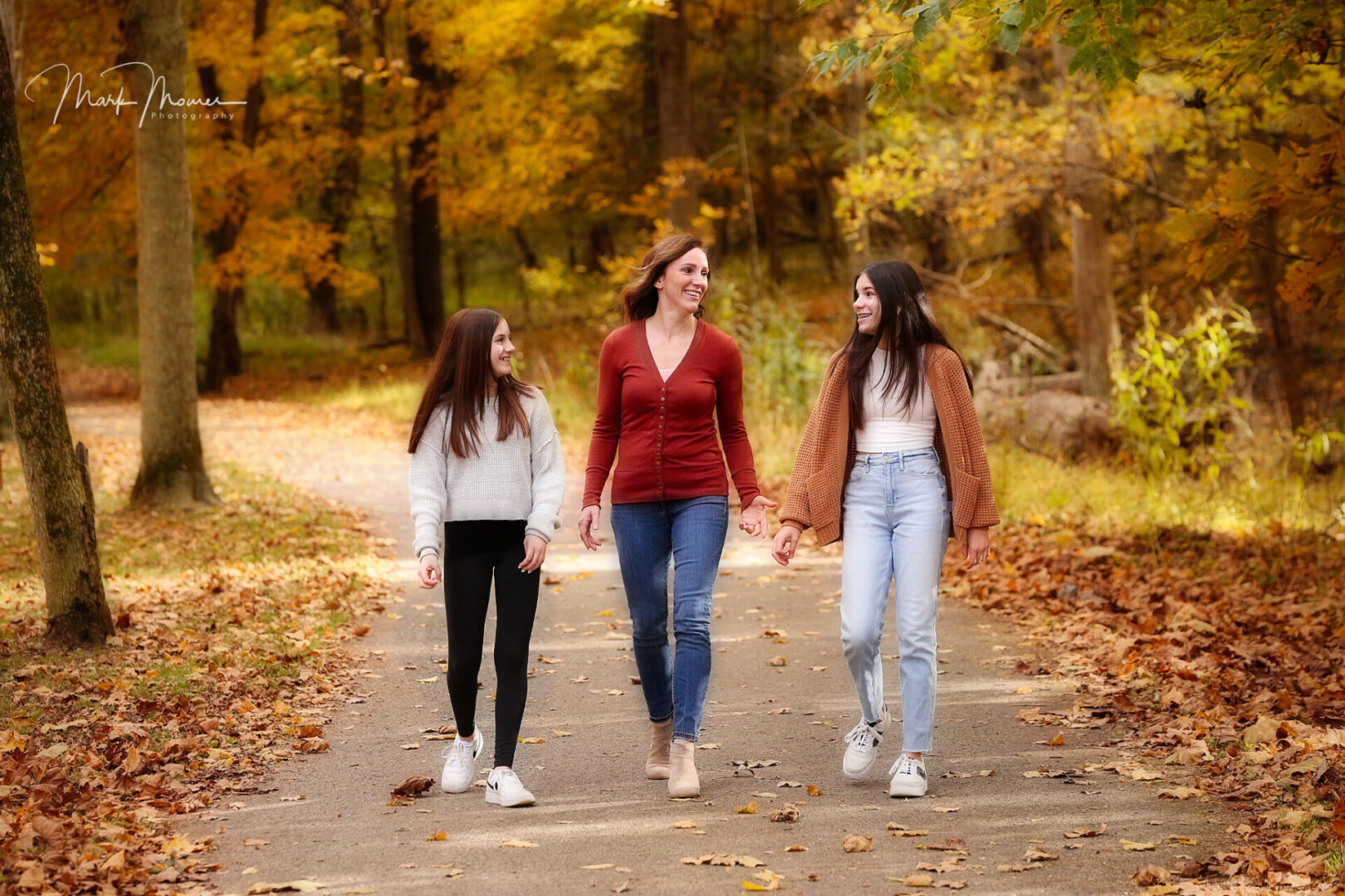 Mother and two daughters walking through a park