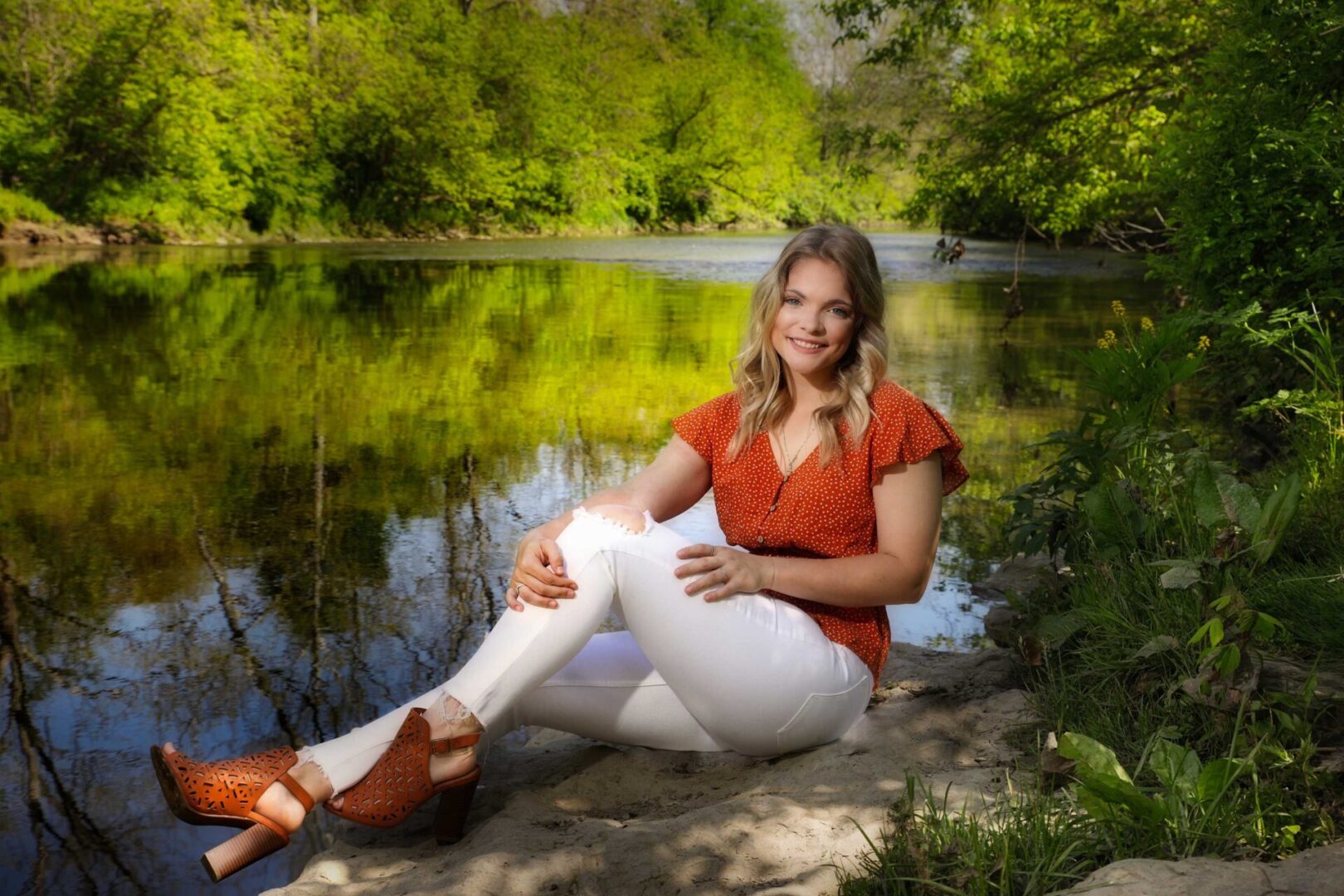 senior girl posing in front of a lake