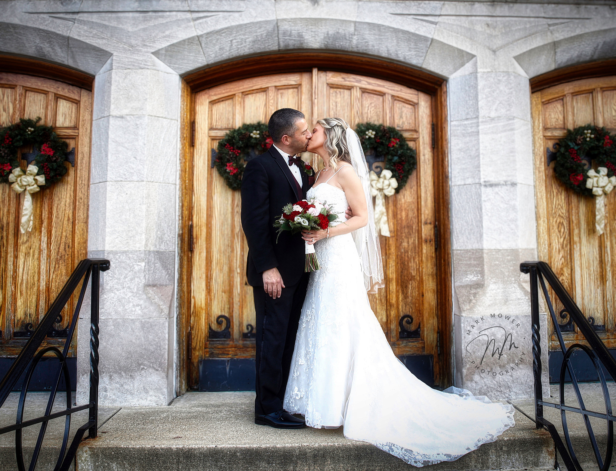 bride and groom kissing on the steps of a church